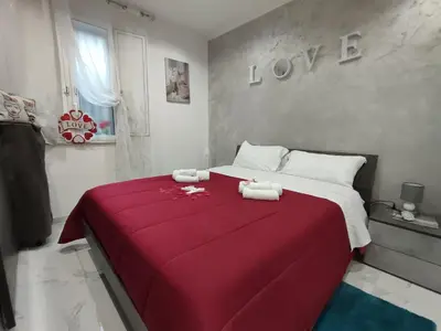 a bedroom with a red bed with towels on it at La casetta di Davide in Palermo