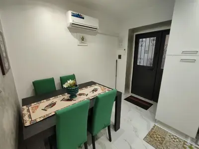 a dining room with a table and green chairs at La casetta di Davide in Palermo