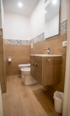 a bathroom with a toilet and a sink and a mirror at L'angolo di Leo in Isola delle Femmine
