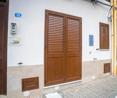 a wooden door on the side of a building at L'angolo di Leo in Isola delle Femmine