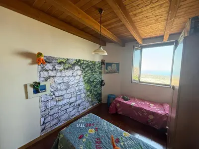 a bedroom with two beds and a stone wall at Villa Shanti a Romitello - 
