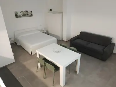 a room with a bed and a table and a couch at Casa vacanze LoRiLù in Castellammare del Golfo