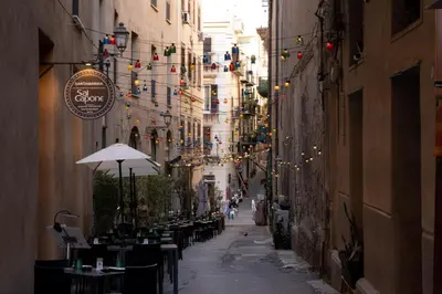a narrow alley with tables and chairs and lights at Boutique Apartment 