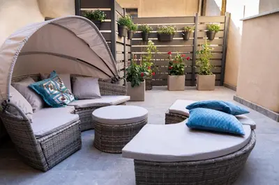 a patio with wicker chairs and tables and potted plants at Boutique Apartment 