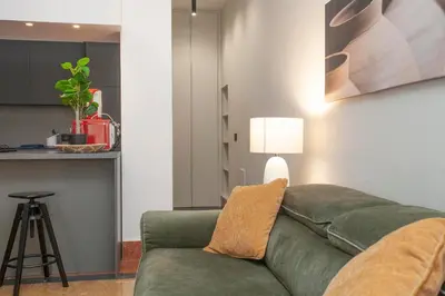 a living room with a green couch and a stool at Sella Apartment Centro Storico in Palermo
