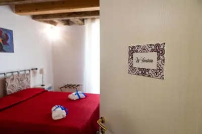a bedroom with a red bed with a sign on the wall at Ai Mercati di Palermo in Palermo