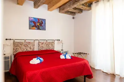 a bedroom with a red bed with a red blanket at Ai Mercati di Palermo in Palermo