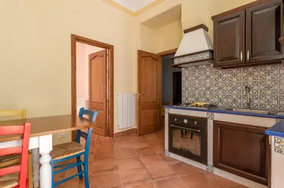 a kitchen with a table and a stove at Il Cortile degli Aragonesi by Wonderful Italy in Palermo