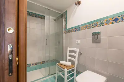a bathroom with a shower and a toilet and a stool at Il Cortile degli Aragonesi by Wonderful Italy in Palermo