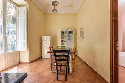 a kitchen with a table and a refrigerator at Il Cortile degli Aragonesi by Wonderful Italy in Palermo