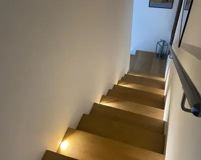 a staircase with wooden floors and lights on the wall at marinellahomeandsea in Palermo