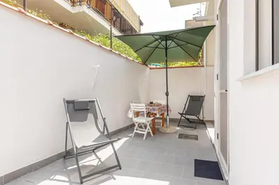 a patio with an umbrella and a table and chairs at La Casetta Donna Vita a Mondello by Wonderful Italy in Palermo
