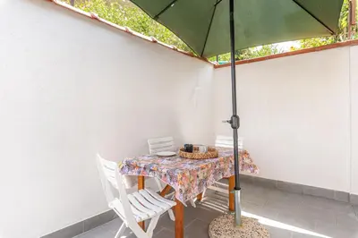 a table and chairs with an umbrella on a patio at La Casetta Donna Vita a Mondello by Wonderful Italy in Palermo