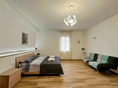 a bedroom with a bed and a couch at Casa Sole eventi, Wi-Fi, fronte Mare con piscina in Alcamo