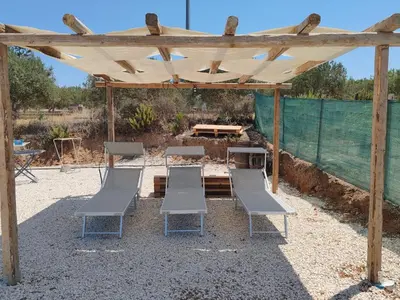 a group of chairs and a wooden pergola at Casa Sole eventi, Wi-Fi, fronte Mare con piscina in Alcamo