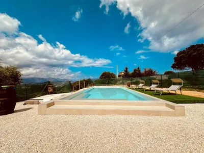 a swimming pool with chairs and a blue sky at Casa Sole eventi, Wi-Fi, fronte Mare con piscina in Alcamo