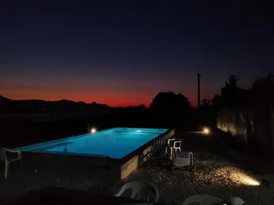 a swimming pool at night with a sunset in the background at Casa Sole eventi, Wi-Fi, fronte Mare con piscina in Alcamo