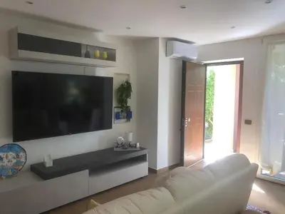a living room with a white couch and a flat screen tv at Mondello House Lemon in Palermo