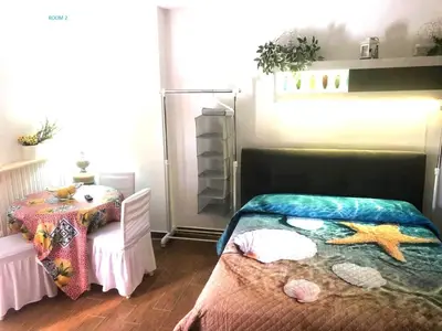 a bedroom with a bed and a table in it at Mondello House Lemon in Palermo