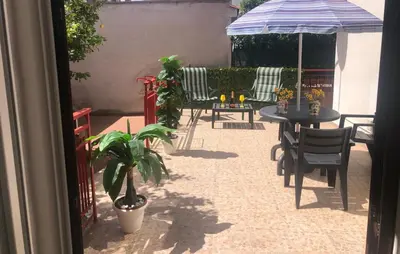 a patio with a table and chairs and an umbrella at Mondello House Lemon in Palermo