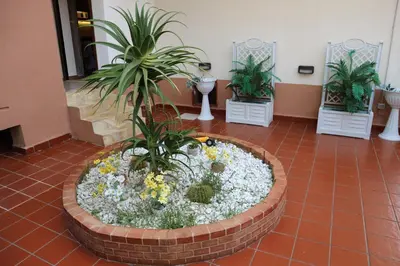 a large planter with plants and flowers in a lobby at Mondello House Lemon in Palermo