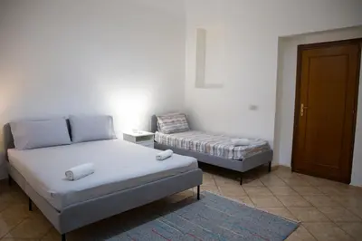 a bedroom with a bed and a chair in it at La Casetta della Nonna in Palermo