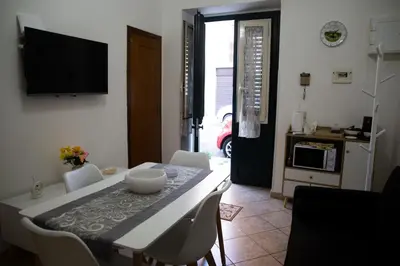 a dining room with a table and chairs and a television at La Casetta della Nonna in Palermo