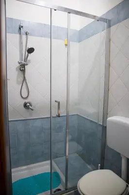 a bathroom with a glass shower with a toilet at La Casetta della Nonna in Palermo
