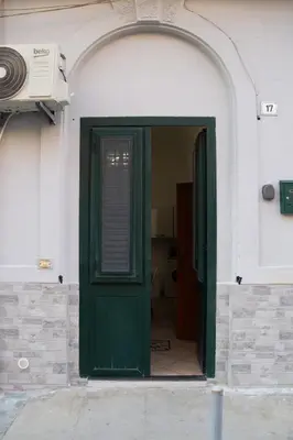 a green door in a building with an arch at La Casetta della Nonna in Palermo