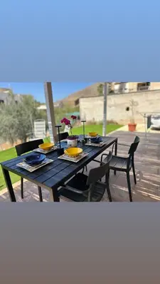 a blue table with plates and flowers on it at Casa Vacanza Villa Corona in San Vito lo Capo