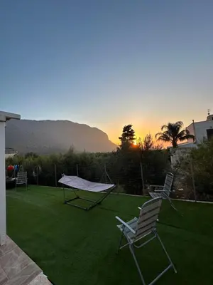 a backyard with two chairs and a ping pong table at Casa Vacanza Villa Corona in San Vito lo Capo