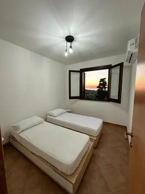 two beds in a room with a window at Casa Vacanza Villa Corona in San Vito lo Capo