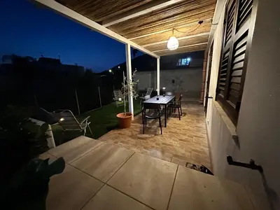 a patio with a table and chairs at night at Casa Vacanza Villa Corona in San Vito lo Capo