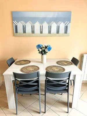 a dining room table with chairs and a vase of flowers at Appartamento Trinacria in Castellammare del Golfo