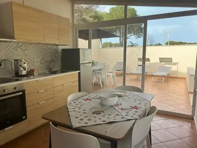 a kitchen and dining room with a table and chairs at Monte Luna - E-bikes incluse per raggiungere il centro e la spiaggia in 3 minuti in San Vito lo Capo