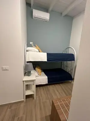 a small room with two bunk beds and a table at Monte Luna - E-bikes incluse per raggiungere il centro e la spiaggia in 3 minuti in San Vito lo Capo