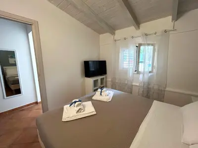 a living room with a table and a tv at Monte Luna - E-bikes incluse per raggiungere il centro e la spiaggia in 3 minuti in San Vito lo Capo