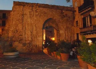an entrance to a stone building with potted plants at Alloggio delle Carrozze al Ballarò in Palermo