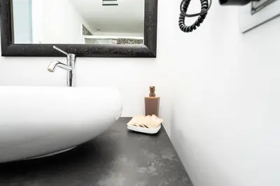 a bathroom with a white sink and a mirror at Maison d'art Orleans in Palermo