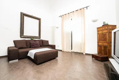 a living room with a couch and a tv at Maison d'art Orleans in Palermo