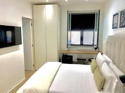 a white bedroom with a large bed and a window at Normanni 5 Rooms & Apartment in Palermo