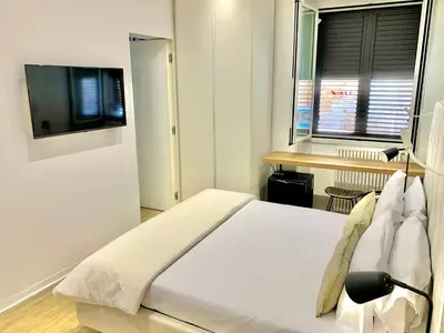 a bedroom with a large white bed with a window at Normanni 5 Rooms & Apartment in Palermo