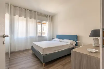a white bedroom with a bed and a window at Appartamento Pacini by Wonderful Italy in Palermo