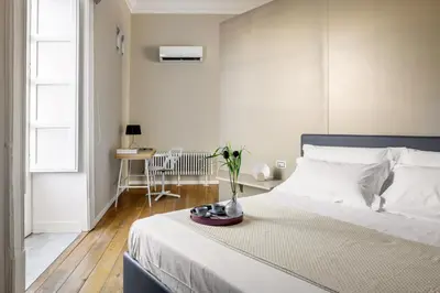 a bedroom with a bed with a vase of flowers on it at Maruisa suite apartment in Palermo
