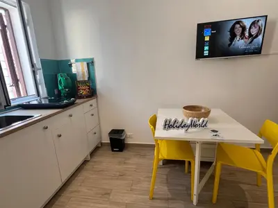 a kitchen with a white table and yellow chairs at Home al Capo by Holiday World in Palermo