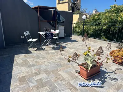 a patio with a table and a potted plant at Home al Capo by Holiday World in Palermo