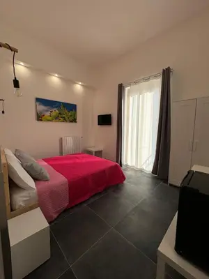 a bedroom with a red bed and a window at My Happy Place Rooms in Palermo