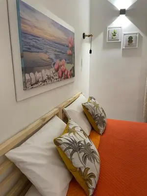 two pillows on a bed with a painting on the wall at My Happy Place Rooms in Palermo
