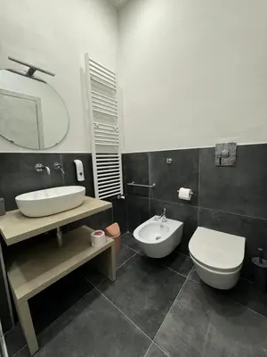 a bathroom with a sink and a toilet and a mirror at My Happy Place Rooms in Palermo