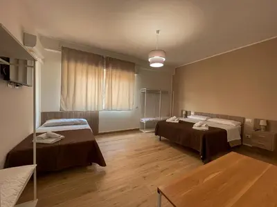 a room with two beds and a table in it at Casa Margherita in Termini Imerese